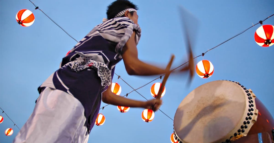 A picture of a guy drumming at a summer festival with lanterns hanging in the air. This picture is energetic and you should be too, if you're going to sell in Japan.