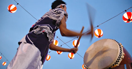 A picture of a guy drumming at a summer festival with lanterns hanging in the air. This picture is energetic and you should be too, if you're going to sell in Japan.