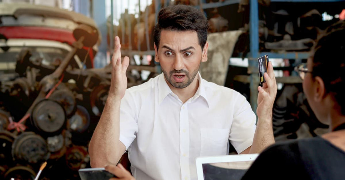 A man stares in bewilderment while holding a credit card. He's probably looking at a shipment invoice. All of this could have been avoided if he'd just read (or listened) to this blog post.