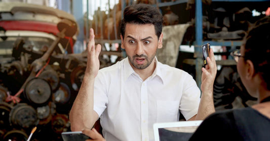 A man stares in bewilderment while holding a credit card. He's probably looking at a shipment invoice. All of this could have been avoided if he'd just read (or listened) to this blog post.