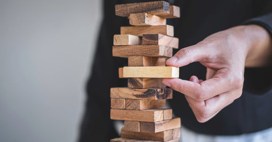 A picture of a hand pulling out a Jenga piece. This is a metaphor for how precarious global trade is, or something like that. Tariffs. Meh.