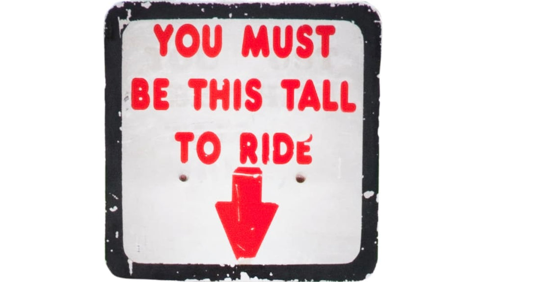 A sign like that kind you would see (sorry, is that insensitive? Would "find" be the better word here?) in front of a rollercoaster. It says "You Must Be This Tall To Ride"